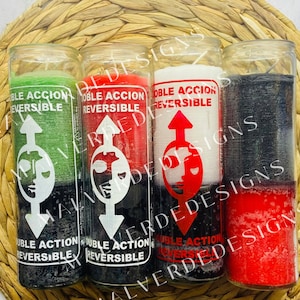 May include: Four glass candle jars containing black, red, white, and green wax. Each jar features a label that reads "Doble Accion Reversible" with an arrow pointing upwards and a stylised face with two halves.