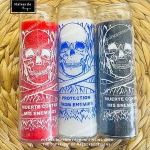 May include: Three glass jar candles with skull designs. One is red with "MUERTE CONTRA MIS ENEMIGOS" text, one is white with "PROTECTION FROM ENEMIES" text, and one is black with the same text as the red candle. All have white skull graphics.