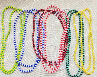 May include: A set of six beaded necklaces in various colors, including yellow, green, blue, white, red, and black. The necklaces are made of small, round beads and are arranged in a circular pattern.