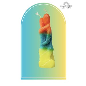 May include: A colorful, twisted candle with a gradient of orange, blue, green, and yellow. The candle has two wicks and is set against a gradient background. The brand name "MALVERDE DESIGNS" is in the top right corner.