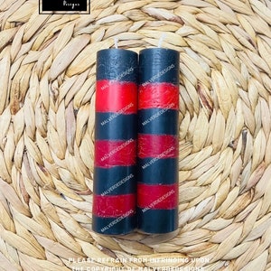 May include: Two black and red striped candles with the text "Malverde Designs" repeated on each candle.