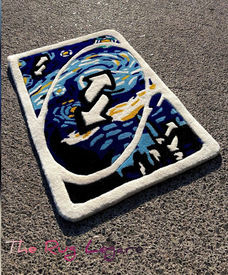 May include: A rectangular rug with a white border and a design inspired by Van Gogh's "Starry Night" painting. The rug features a large white arrow in the center, with blue, yellow, and black accents.