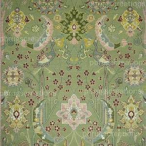 Könnte beinhalten: Ein rechteckiger Teppich mit salbeigrünem Hintergrund und einem symmetrischen Muster aus stilisierten Vögeln, Blumenmotiven und geometrischen Formen in Rosa, Gelb, Blau und Dunkelrot, der an den Rändern mit kurzen Fransen versehen ist.