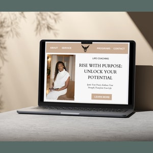 Op de afbeelding: Het scherm van een laptopcomputer waarop een website voor een life coach te zien is. De website toont een foto van een vrouw en de tekst "Rise with Purpose: Unlock Your Potential. Ignite Your Power, Embrace Your Strength, Transform Your Life. Learn More."