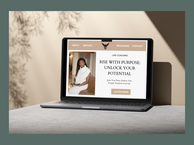 Op de afbeelding: Het scherm van een laptopcomputer waarop een website voor een life coach te zien is. De website toont een foto van een vrouw en de tekst "Rise with Purpose: Unlock Your Potential. Ignite Your Power, Embrace Your Strength, Transform Your Life. Learn More."