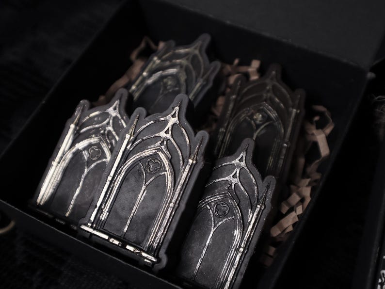 May include: A set of five black and silver gothic archway-shaped stickers in a black box with brown packing paper.