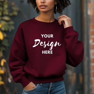 Puede incluir: Una sudadera color burdeos con el texto "YOUR Design HERE" en blanco.