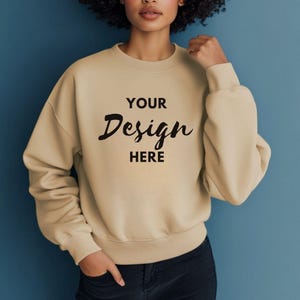 Puede incluir: Una sudadera beige con el texto "YOUR Design HERE" impreso en la parte delantera.