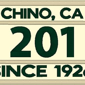 May include: A white rectangular sign with black text that reads "CHINO, CA 201 SINCE 1926".