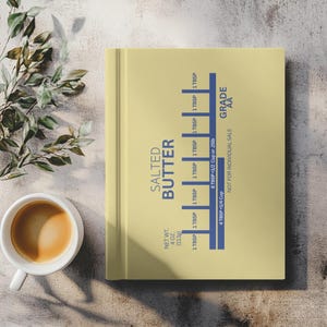 May include: A light yellow cookbook with the words "SALTED BUTTER" in blue. The book has a butter conversion chart with measurements in tablespoons, cups, and pounds. The net weight is 113g. The grade is AA.