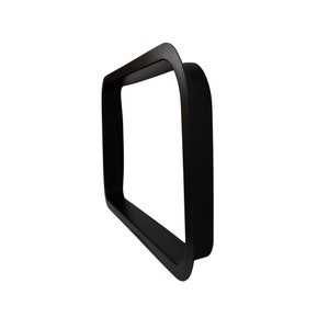 May include: A black, square frame with rounded corners. The frame has a thick, solid construction and a matte finish. The design is minimalist and modern, suitable for various decorative purposes.