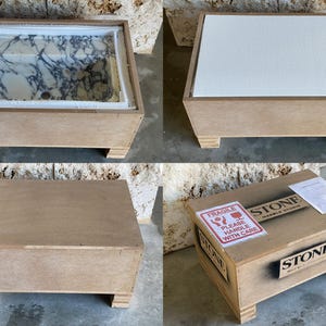 Puede incluir: Una caja de madera que contiene una pila de m&aacute;rmol con un patr&oacute;n blanco y gris. La caja est&aacute; hecha de madera marr&oacute;n claro y tiene forma rectangular con cuatro patas cortas. La caja est&aacute; etiquetada como "STONE MARBLE STUDIO".