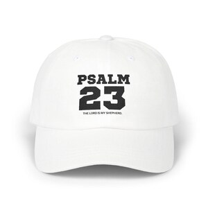 May include: A white baseball cap with the text "PSALM 23" in black block letters. Below the numbers is the text "THE LORD IS MY SHEPHERD."