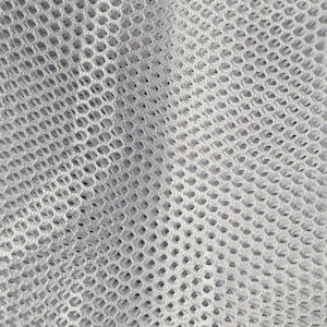 May include: Close-up of a white mesh fabric with a diamond pattern. The fabric is soft and flexible, and it has a slightly textured surface.