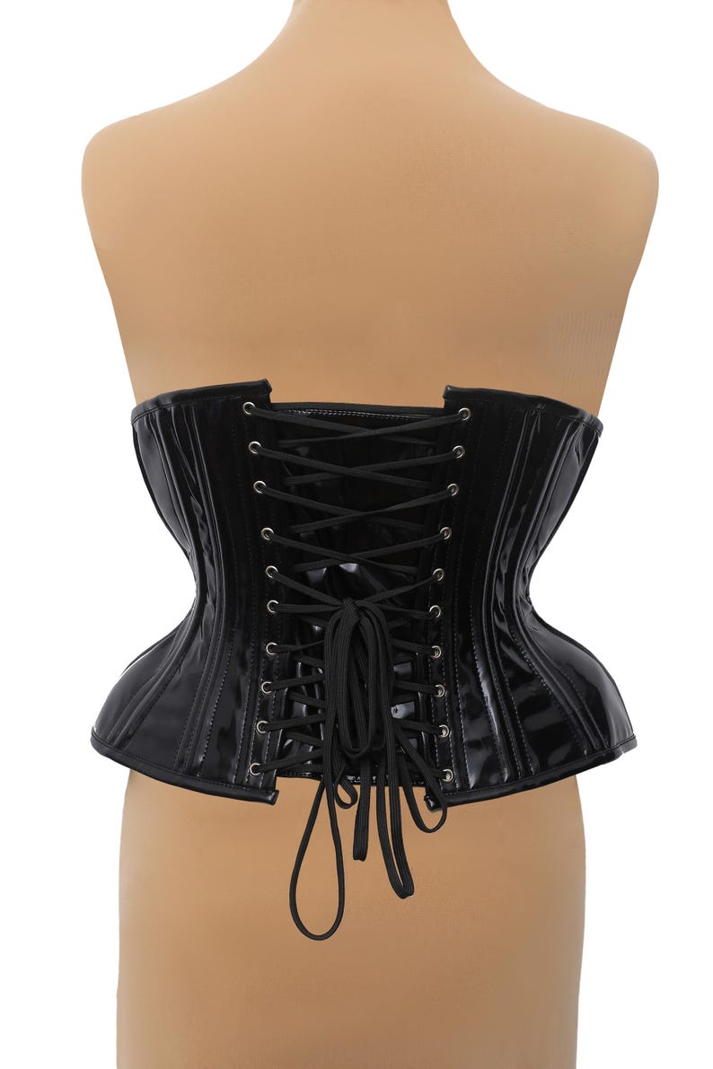 Puede incluir: Cors&eacute; de charol negro con lazada en la espalda. El cors&eacute; tiene una estructura con varillas y un acabado liso y brillante.