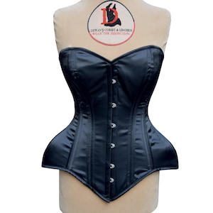 Könnte beinhalten: Ein schwarzes Satin-Korsett mit einem herzförmigen Ausschnitt und einem Busk-Verschluss. Das Korsett hat eine glatte, elegante Oberfläche und trägt ein dekoratives Etikett mit dem Text "Dewan's Corset & Lingerie - Wear the Perfection."