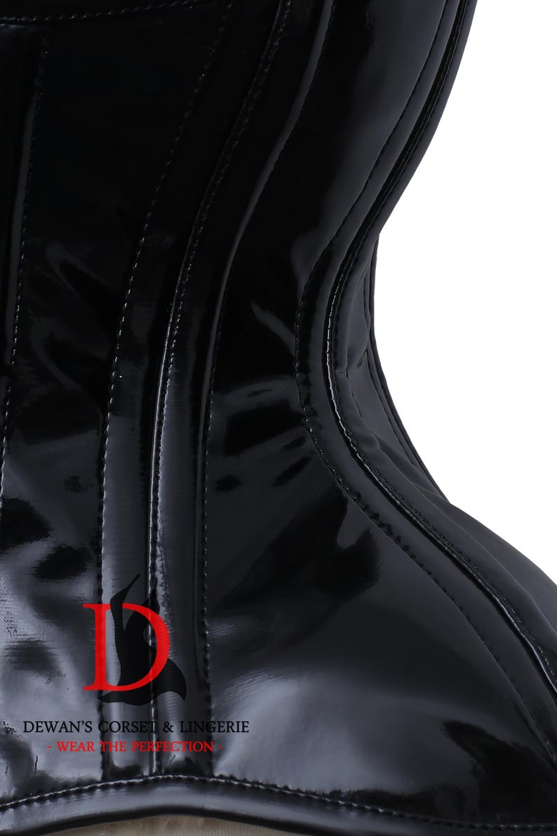 Puede incluir: Un cors&eacute; de charol negro con un logotipo D y el texto "DEWAN'S CORSET & LINGERIE - WEAR THE PERFECTION" en la parte delantera.