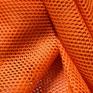 May include: Orange mesh fabric with a diamond pattern. The fabric is folded and shows the texture of the material.