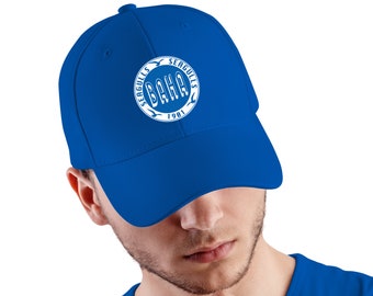 May include: Royal blue baseball cap with a curved brim. The cap features a white circular emblem with the text "BAHA SEAGULLS 1981". The cap is made of a durable material and has a structured fit.