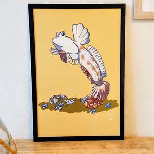 May include: A framed illustration of a white and orange fish with a yellow background. The fish is jumping out of the water and has a pink and white tail. There are small blue and white flowers on the bottom of the image.