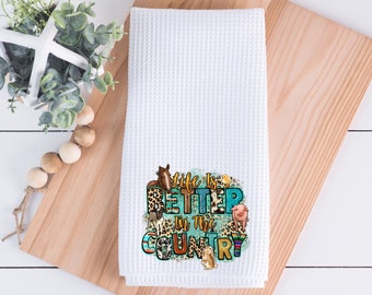 May include: White waffle kitchen towel with a colourful graphic print of farm animals and the text "Life is Better in the Country".