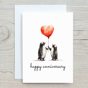 May include: A greeting card with a watercolor illustration of two penguins holding a red heart-shaped balloon that says "A+B". The text "happy anniversary" is written below the penguins.