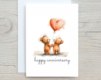 Op de afbeelding: Een aquarel jubileumkaart met twee bruine teddyberen die elkaars hand vasthouden, met een hartvormige ballon. De ballon heeft de initialen "A+B" en de woorden "happy anniversary" staan eronder.
