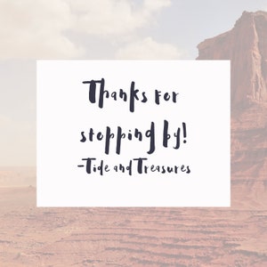 May include: White card with black handwritten text that says "Thanks for stopping by! - Tide and Treasures" against a blurred background of a red rock formation.