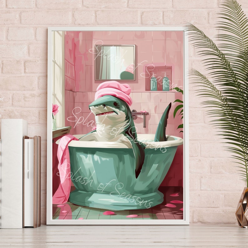 Op de afbeelding: Een wit ingelijste illustratie van een haai die een roze badjas draagt en een bad neemt in een groene badkuip. De badkamer is roze met witte tegels en een spiegel. De haai glimlacht en heeft een roze badjas op zijn hoofd.