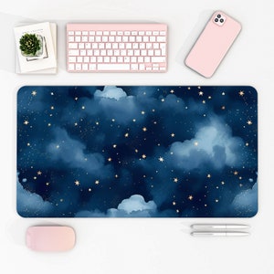 May include: A blue and gold desk mat with a watercolor design of clouds and stars. The mat is perfect for adding a touch of whimsy to your workspace.