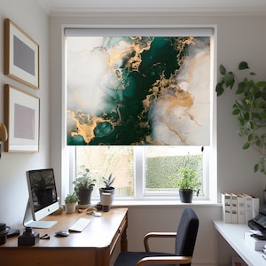 Op de afbeelding: Een groene, witte en gouden abstracte rolgordijn met een marmerpatroon. De rolgordijn is geïnstalleerd in een raam in een thuiskantoor.