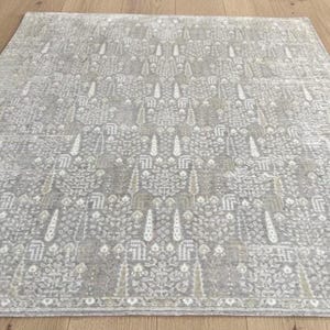 Alfombra de seda anudada en telar para decoración de lujo del hogar, hecha a mano en beige y plata, de lana y viscosa, con diseño de altura variable.