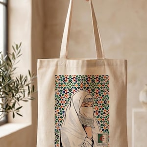 May include: Beige tote bag featuring an illustration of a woman wearing a white hijab and veil, set against a colorful geometric pattern. The bag includes the flag of Algeria and the word "Algeria".
