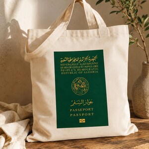 May include: A beige tote bag with a green rectangle featuring text in Arabic, French, and English. The text includes "REPUBLIQUE ALGERIENNE" and "PASSEPORT". The bag is made of a light-colored fabric and has two handles.