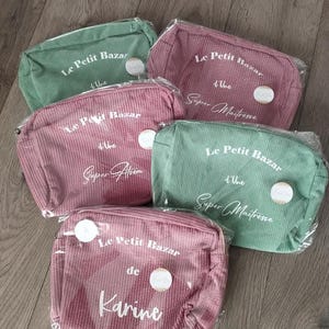 Pu&ograve; includere: Cinque trousse per cosmetici in velluto a coste rosa e verde, ciascuna con chiusura a zip. Il testo sulle borse recita "Le Petit Bazar" e varie frasi. Le borse sono confezionate in plastica trasparente.