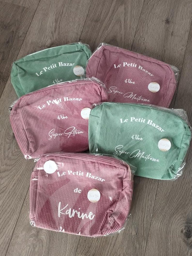 Pu&ograve; includere: Cinque trousse per cosmetici in velluto a coste rosa e verde, ciascuna con chiusura a zip. Il testo sulle borse recita "Le Petit Bazar" e varie frasi. Le borse sono confezionate in plastica trasparente.