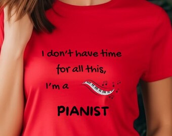 May include: A red t-shirt with the text "I don't have time for all this, I'm a PIANIST" in black. The design includes a piano keyboard and musical notes. The shirt is short-sleeved.