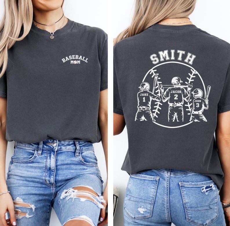 Puede incluir: Una camiseta gris oscuro con el texto "Baseball Mom" en la parte delantera y un dise&ntilde;o de b&eacute;isbol con el texto "Smith" y los nombres "Jake", "Jacob" y "John" en la parte posterior.