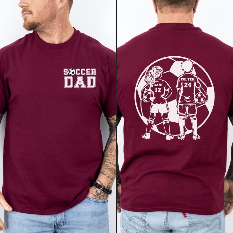 May include: Burgundy t-shirt with the text "SOCCER DAD" in white on the front. The back features a white graphic of two soccer players with the names "DANI 12" and "COLTEN 24" inside a soccer ball.
