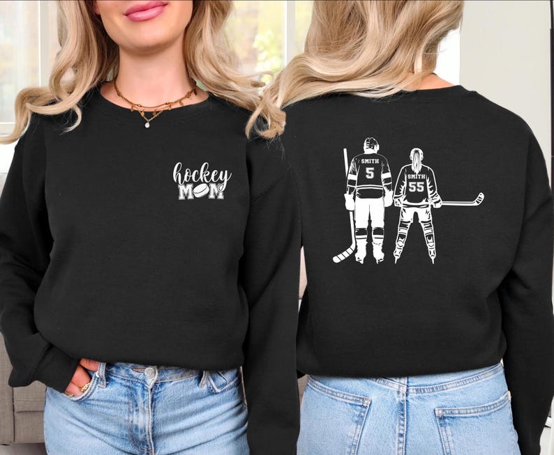 May include: Black sweatshirt with the text "hockey MOM" in white script and a hockey puck graphic. The back of the sweatshirt features a white graphic of two hockey players with the name "Smith" and numbers 5 and 55.