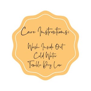 May include: A yellow star-shaped tag with white text that reads "Care Instructions: Wash Inside Out Cold Water Tumble Dry Low".