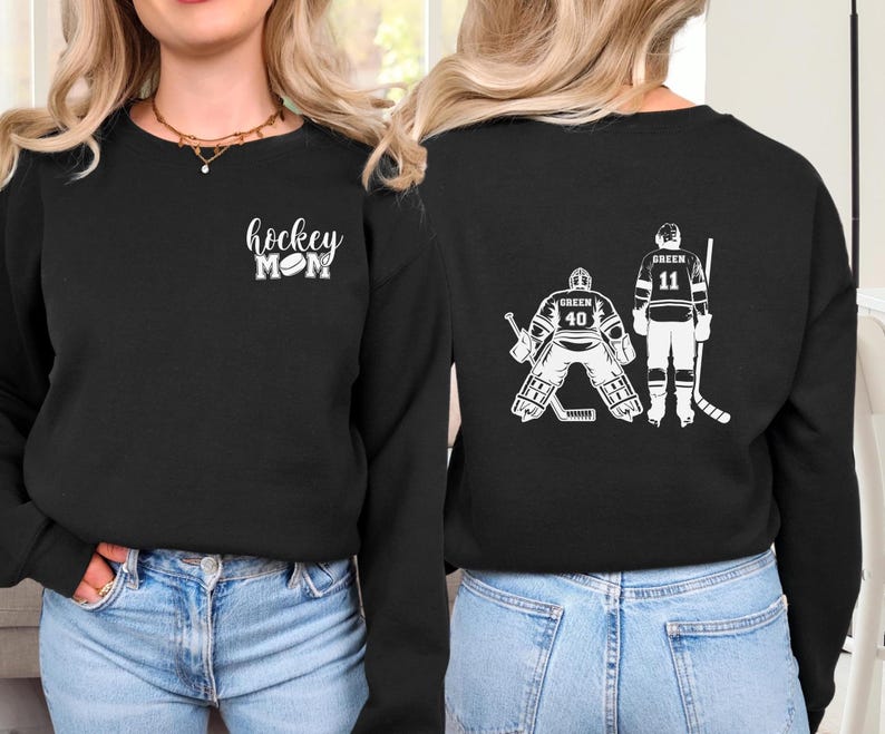 May include: Two black long-sleeved shirts with a hockey theme. One shirt says "hockey mom" with a hockey puck. The other shirt has two hockey players, one with the number 40 and the other with the number 11.