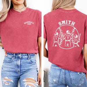 Puede incluir: Camiseta roja de mam&aacute; de b&eacute;isbol con el texto "Baseball Mom" en la parte delantera y un dise&ntilde;o de b&eacute;isbol con el texto "Smith" y tres jugadores con nombres y n&uacute;meros en la parte posterior.