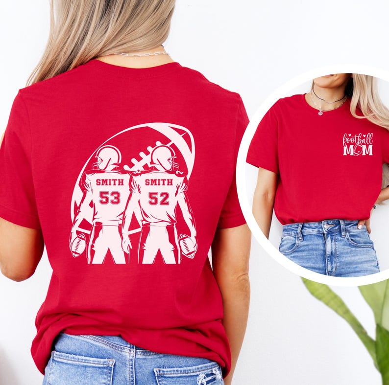 May include: Red t-shirt with a white graphic of two football players inside a football shape. The players have the name "Smith" and numbers 53 and 52. A smaller image shows a red t-shirt with "football MOM" text.