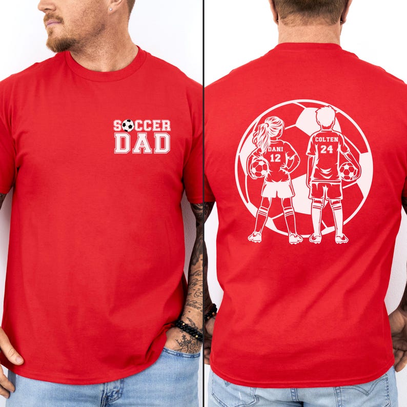 May include: Red t-shirt with white text that says "SOCCER DAD" on the front. The back of the shirt features a white graphic of two soccer players inside a soccer ball, with the names "DANI 12" and "COLTEN 24".