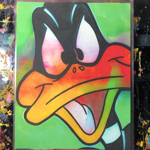 May include: A colorful cartoon duck with an angry expression. The duck is drawn in a graffiti style with bright colors and black outlines. The background is a green color.