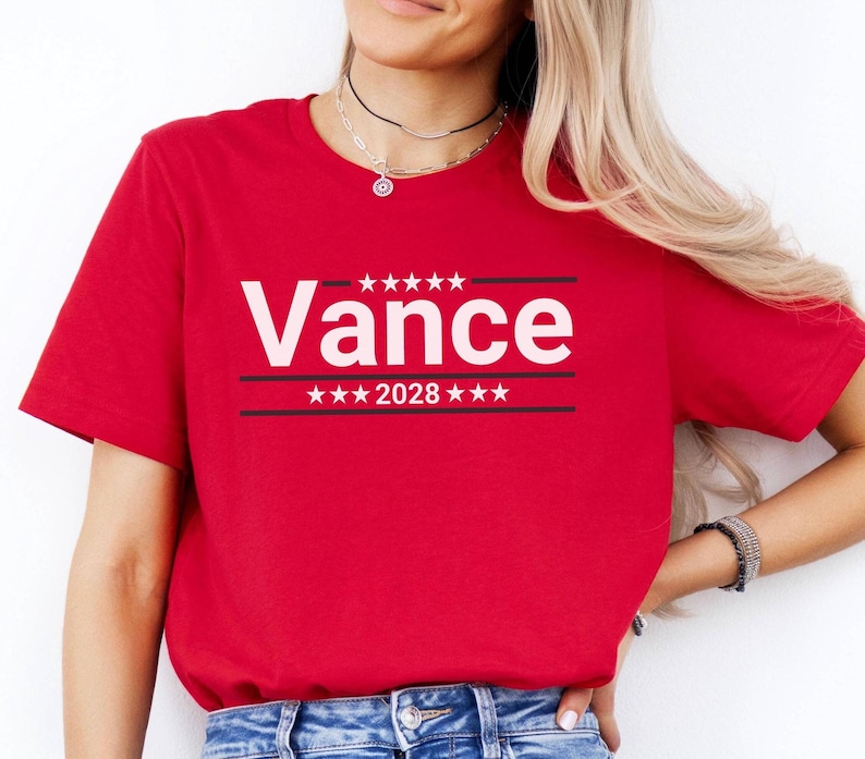 May include: Red t-shirt with white text that says "Vance 2028" with stars above and below the text.
