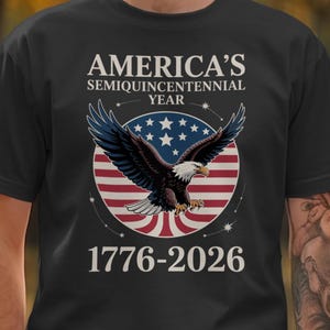 May include: Black t-shirt with a white eagle graphic on a red, white, and blue American flag circle. The text "America's Semiquincentennial Year 1776-2026" is printed on the shirt.