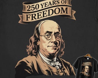 May include: Black t-shirt featuring a portrait of Benjamin Franklin with the text "250 Years of Freedom" in a banner above. A smaller image of the shirt is displayed on a hanger. The design is in shades of brown and tan.