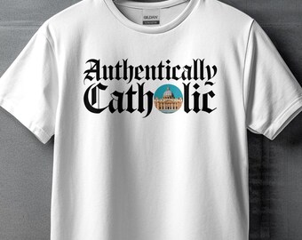 Peut inclure: T-shirt blanc avec un texte noir qui dit "Authentiquement catholique" et une petite image de la basilique Saint-Pierre au Vatican.